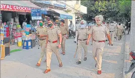  ?? RAVI KUMAR/HT ?? Chandigarh Police personnel taking out a flag march at congested Burail market in Sector 45, Chandigarh, on Monday.