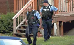  ?? DAVID CARSON/AP ?? Members of the St. Louis Police Department work near the scene of a shooting Saturday. Two officers were shot as a standoff developed.