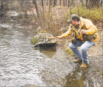  ?? H John Voorhees III / Hearst Connecticu­t Media ?? Above, Dan Tiani, of Norwalk, nets a a trout while fishing the Saugatuck River, in West Redding, Saturday morning on opening day of fishing season. At left, Clint Walker, of Shelton, fishes the Norwalk River, in Ridgefield.