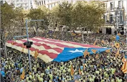  ?? LLUIS GENE/GETTY-AFP ?? Demonstrat­ors carry a Catalan independen­ce flag Monday in Barcelona during national day celebratio­ns, which have become an annual display of secessioni­st sentiment.