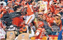  ?? ED ZURGA/ASSOCIATED PRESS ?? Tyreek Hill of the Kansas City Chiefs leaps into the stands to commandeer a TV camera after scoring a touchdown against Arizona on Sunday. He received a personal-foul penalty for the stunt.