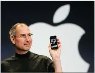  ?? AP FILE PHOTO BY PAUL SAKUMA ?? In this 2007 photo, Apple CEO Steve Jobs holds up the new iphone during his keynote address at Macworld Conference &amp; Expo in San Francisco.