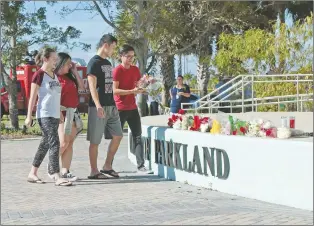  ?? AP PHOTO ?? Students place flowers on the stage outside the Pines Trail Center where a candleligh­t vigil will be held, Thursday, Feb. 15, 2018, in Parkland, Fla.