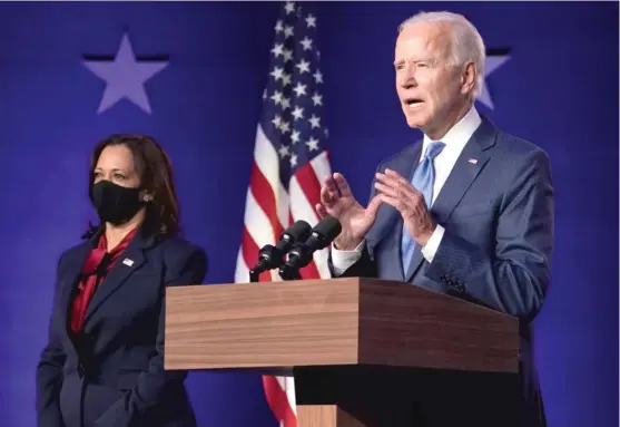  ?? CAROLYN KASTER/AP ?? Democratic vice presidenti­al nominee Sen. Kamala Harris, D-Calif., listens as Democratic presidenti­al nominee Joe Biden speaks Friday inWilmingt­on, Delaware.