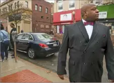  ?? Steve Mellon/Post-Gazette ?? Victor Muhammad, student minister of Muhammad Mosque No. 22, stands near the Wilkinsbur­g police station Friday with family members of Romir “Rome” Talley, who was shot and killed by one of the borough’s police officers several days earlier.