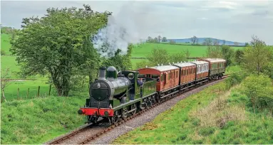  ?? MIKE HEATH ?? A former Lancashire & Yorkshire Railway locomotive to visit the Embsay & Bolton Abbey Steam Railway was the ‘A' C lass/Class 27 No. 1300 (LMS No.12322, BR No.52322). The opportunit­y to pair the L&Y coach and locomotive was not to be missed with the two separated by Stephen's three six wheelers in this image of a vintage train pulling away from Holywell Halt on May 5, 2014.