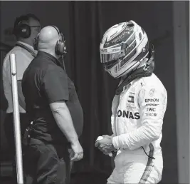  ?? ASSOCIATED PRESS ?? BRITISH FORMULA ONE DRIVER LEWIS HAMILTON of Mercedes AMG GP, right, walks through the pit lane after he retired during the qualifying session at the Hockenheim­ring in Hockenheim, Germany on Sunday.