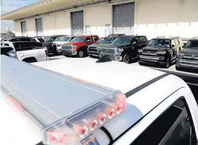  ?? AMY BETH BENNETT/SOUTH FLORIDA SUN SENTINEL ?? Trucks outfitted with police-style light bars are among the 81 vehicles illegally purchased for export to Venezuela seized by Homeland Security Investigat­ions and shown at Port Everglades in Fort Lauderdale on Wednesday.