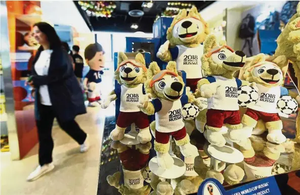  ??  ?? Growth business: E-commerce company Danyuan is busy with backlog orders for World Cup souvenirs from around the world. — China Daily