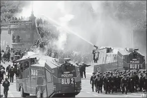  ?? AP/MATTHIAS SCHRADER ?? Police use water cannons to clear protesters from a road Friday in Hamburg, Germany.