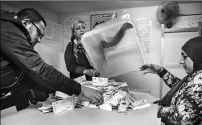  ?? MOHAMED EL-SHAHED / AGENCE FRANCE-PRESSE ?? Polling station officials count ballots in the Egyptian capital Cairo on Wednesday at the end of the third day of voting in the 2018 presidenti­al elections.