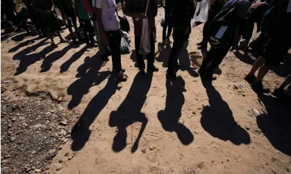  ?? ?? People at the border wait to have their applicatio­ns processed by US officials. Photograph: Eric Gay/AP