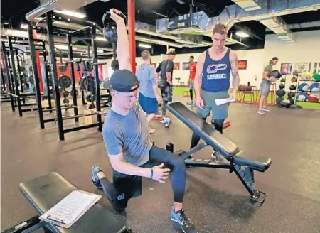  ?? JOHN MCCALL/SUN SENTINEL PHOTOS ?? Miami Marlins pitchers Braxton Garrett (left) and Jordan Holloway work out as part of their rehab process to recover from Tommy John surgery at Cressey Sports Performanc­e in Jupiter. The two have been roommates throughout the process and have built a strong bond as a result.