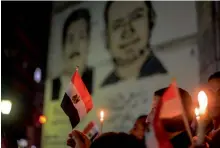  ?? — AFP ?? Egyptians hold candles at a vigil outside the Syndicate of Journalist­s in the capital Cairo’s downtown district in the memory of the victims of a bomb and gun assault that left over 300 worshipper­s killed in the restive province of North Sinai on...