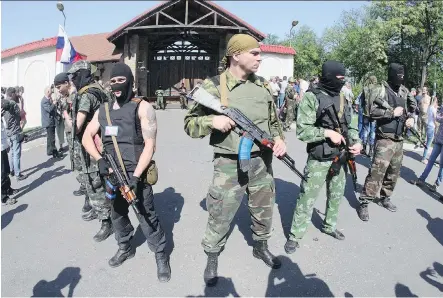  ?? GETTY IMAGES/ FILES ?? Pro- Russian armed militants stand guard in front of the residence of Rinat Akhmetov, the richest Ukrainian oligarch and a main sponsor of the former Ukrainian president of the pro- Russian Regions Party, in Donetsk in 2014.