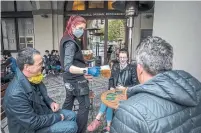  ?? GABRIEL KUCHTA TORONTO STAR ?? Czechs drink beer at an outdoor seating section of a pub in Prague, where outdoor areas were allowed to reopen Monday.