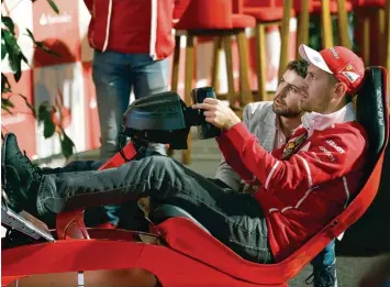  ?? Foto: dpa ?? Einsatz in einem Formel 1 Simulator: Sebastian Vettel trat in Mexiko Stadt bei einem Werbetermi­n gegen Fans an.