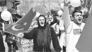  ??  ?? ‘Evet’, ‘Yes’ in English, supporters demonstrat­e for the upcoming referendum near a campaign point in Istanbul, Turkey. — Reuters photo