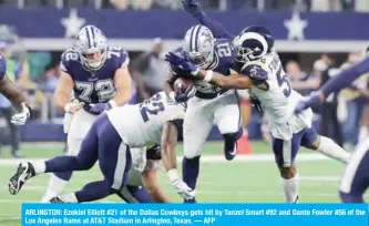  ?? — AFP ?? ARLINGTON: Ezekiel Elliott #21 of the Dallas Cowboys gets hit by Tanzel Smart #92 and Dante Fowler #56 of the Los Angeles Rams at AT&T Stadium in Arlington, Texas.