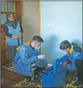  ??  ?? Zeynep Yigit (left) looks on as Kaya (right) and Duran prepare a dose of the CoronaVac vaccine.