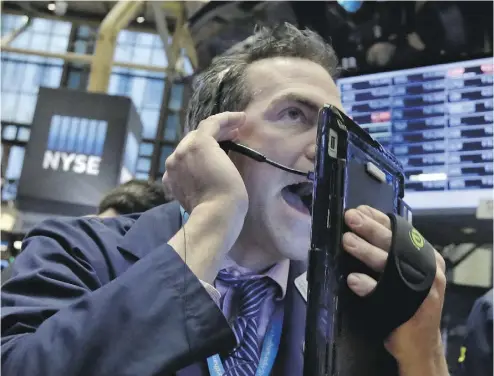  ?? RICHARD DREW / THE ASSOCIATED PRESS ?? Trader Gregory Rowe works on the floor of the New York Stock Exchange on Wednesday. Energy stocks are leading another sell- off on markets as the price of oil continues to plunge.