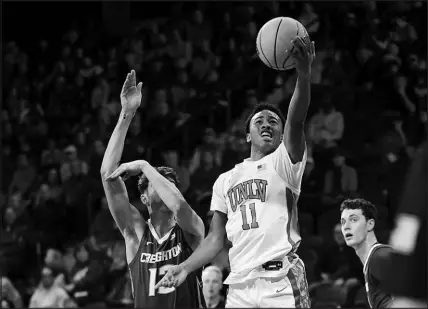  ?? WADE VANDERVORT (2023) ?? UNLV guard D.J. Thomas (11) lays up a shot ahead of Creighton forward Mason Miller (13) during their game Dec. 13 in Henderson. Thomas, who has given every indication he will return next season to UNLV, is a tempting target for potential NCAA transfer portal suitors.