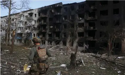  ?? Photograph: Anatolii Stepanov/AFP/Getty Images ?? A Ukrainian police officer walks past a destroyed residentia­l building in Ocheretyne. Russian forces have now reportedly entered the village.