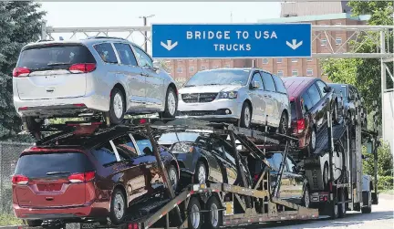  ?? DAN JANISSE ?? A truck loaded with Chrysler Pacifica models makes its way onto the Ambassador Bridge in Windsor, Ont., on Monday. Residents of the Southweste­rn Ontario city dread a potential 25-per-cent tariff on auto imports from Canada could devastate the...