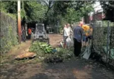  ??  ?? City officials and community volunteers remove trash and debris from Eldon Alley in an effort to clean up the area surroundin­g the former Cook Elementary School in Trenton’s Wilbur section.