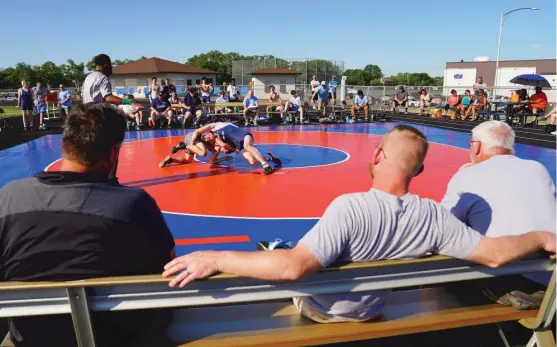  ?? KEVIN TANAKA/SUN TIMES ?? Elmwood Park coaches follow the action on a hot day during a double dual with DePaul Prep and Fenton, which held eight of its 20 wrestling events outdoors.