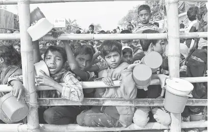  ?? — Gambar AFP ?? PENUH DERITA: Kanak-kanak pelarian warga Rohingya mendapatka­n bekalan makanan yang dihantar ke kem pelarian Thankhali di daerah Ukhia, Bangladesh.