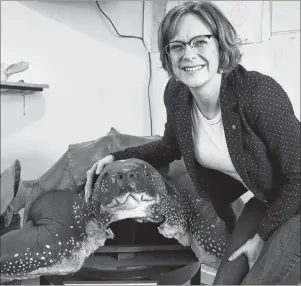  ?? DAVID JALA PHOTOS/CAPE BRETON POST ?? CBRM Coun. Amanda McDougall shows some affection for a replica of a giant Leatherbac­k sea turtle that is on display in the new Oceans of Opportunit­y Marine Science and Heritage Centre in Louisbourg.