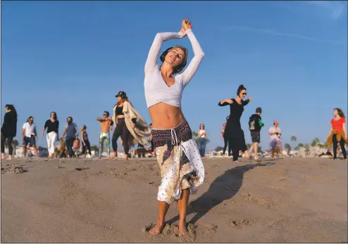  ?? (AP/Jae C. Hong) ?? With music playing through wireless headphones, Chase Beckerman and other participan­ts dance Sept. 29 on the beach during a weekly event hosted by Ecstatic Dance LA on Venice Beach in Los Angeles.