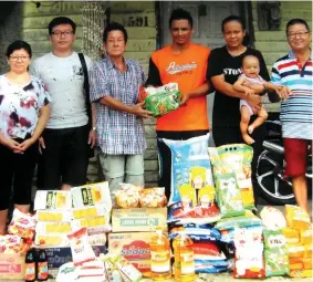  ??  ?? Lim (third left) presents the donations to Qartina’s son Mohd Shukri, witnessed by others.