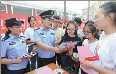  ?? WAN SHANCHAO / FOR CHINA DAILY ?? Police hand out pamphlets on financial risk awareness at a university in Huaibei, Anhui province.