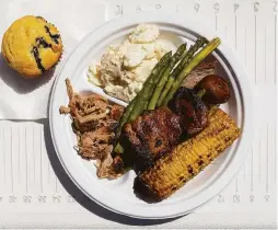  ??  ?? GrilleeQ’s barbecue plate includes pulled pork, tri-tip, chicken thighs and sides of corn on the cob, asparagus and blueberry corn muffins.