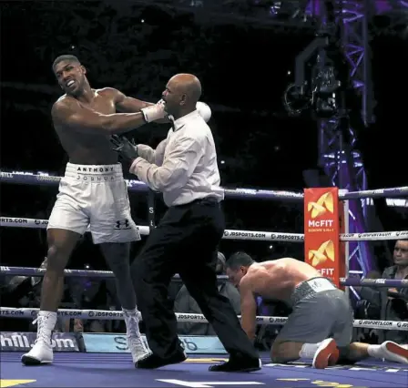  ?? Nick Potts/Associated Press ?? Referee David Fields gets between Anthony Joshua, left and Wladimir Klitschko after Anthony knocked down Klitschko.