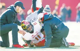  ?? DOUG MCSCHOOLER/ASSOCIATED PRESS ?? Maryland quarterbac­k Kasim Hill grimaces as he is examined by team trainers after an injury during the first half against Indiana.