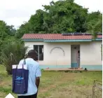  ??  ?? Chairman Mtengo Omari walking towards a community centre in Funzi, Kwale County with a recently installed solar system completed by Sollatek