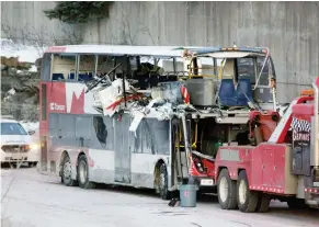  ?? DAVID KAWAI ?? The bus involved in Friday’s crash in Ottawa is towed away, revealing extensive damage. Three people were killed and one person remains in critical condition.