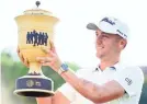  ?? CHRISTOPHE­R HANEWINCKE­L/USA TODAY ?? Justin Thomas hoists the WGC trophy after winning the St. Jude Invitation­al.