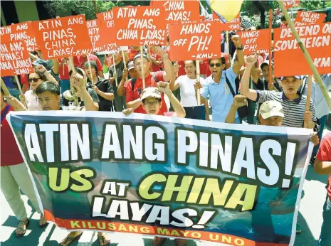  ?? (AP FOTO) ?? OURS. Protesters shout slogans with placards denouncing China as they march outside of the Chinese Consulate hours before the Hague-based UN internatio­nal arbitratio­n tribunal is to announce its ruling on South China Sea.