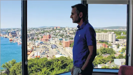  ?? BETH PENNEY/THE TELEGRAM ?? Graduate student Richard Kissoon admires the view from one of the common areas of the MUN Battery Facility. Kissoon was the first graduate student to spend the night at the MUN Battery Facility.