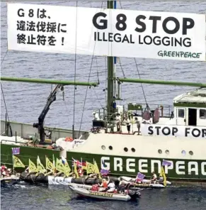  ?? — AP ?? During their protest in Nago Harbour on Japan’s Okinawa island, Greenpeace activists in rubber boats and on its flagship Rainbow Warrior put up a huge banner to call for a stop to the Group of Eight’s illegal logging, on July 21, 2000.