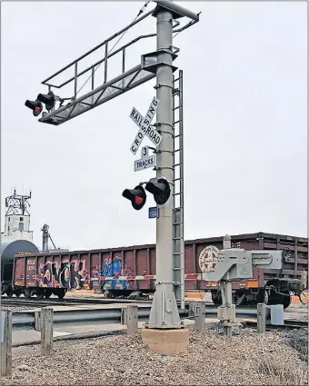  ?? [THE OKLAHOMAN ARCHIVES] ?? A train passes recently through a road-rail intersecti­on in downtown Edmond. A pending House bill, if made law, could allow law enforcemen­t officers to fine railroads in cases where a stopped train blocks such a location for longer than 10 minutes.