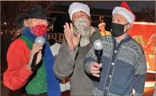  ?? Dan Watson/The Signal ?? From left, Jack Matson, Alex Diksas and Mark Farestveit lipsync for the passing cars during the Bethlehem SCV Christmas Charity Car Cruise in Canyon Country.