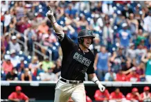  ??  ?? Coastal Carolina’s G.K. Young celebrates his two-run home run off Arizona’s Bobby Dalbec in the sixth inning Thursday in Game 3 of the College World Series finals in Omaha, Neb.