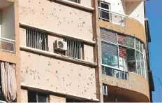  ?? AFP ?? A bullet-ridden building in Tayouneh. TV stations broadcast footage of bullets hitting buildings and people running for cover.