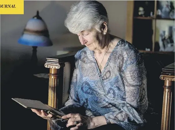  ?? CRAIG ROBERTSON / TORONTO SUN / POSTMEDIA NETWORK ?? Holocaust survivor Hedy Bohm, looking at a small journal that survived the war, spent decades “trying not to remember.” But testifying at the trial of former Nazi Reinhold Hanning was something she needed to do. “I could speak for those who can’t,” she...