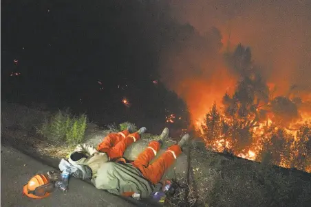  ?? Paul Kuroda / Special to The Chronicle ?? Pine Grove Youth Conservati­on Camp members sleep after two days of fighting the Kincade Fire near the River Rock Casino.